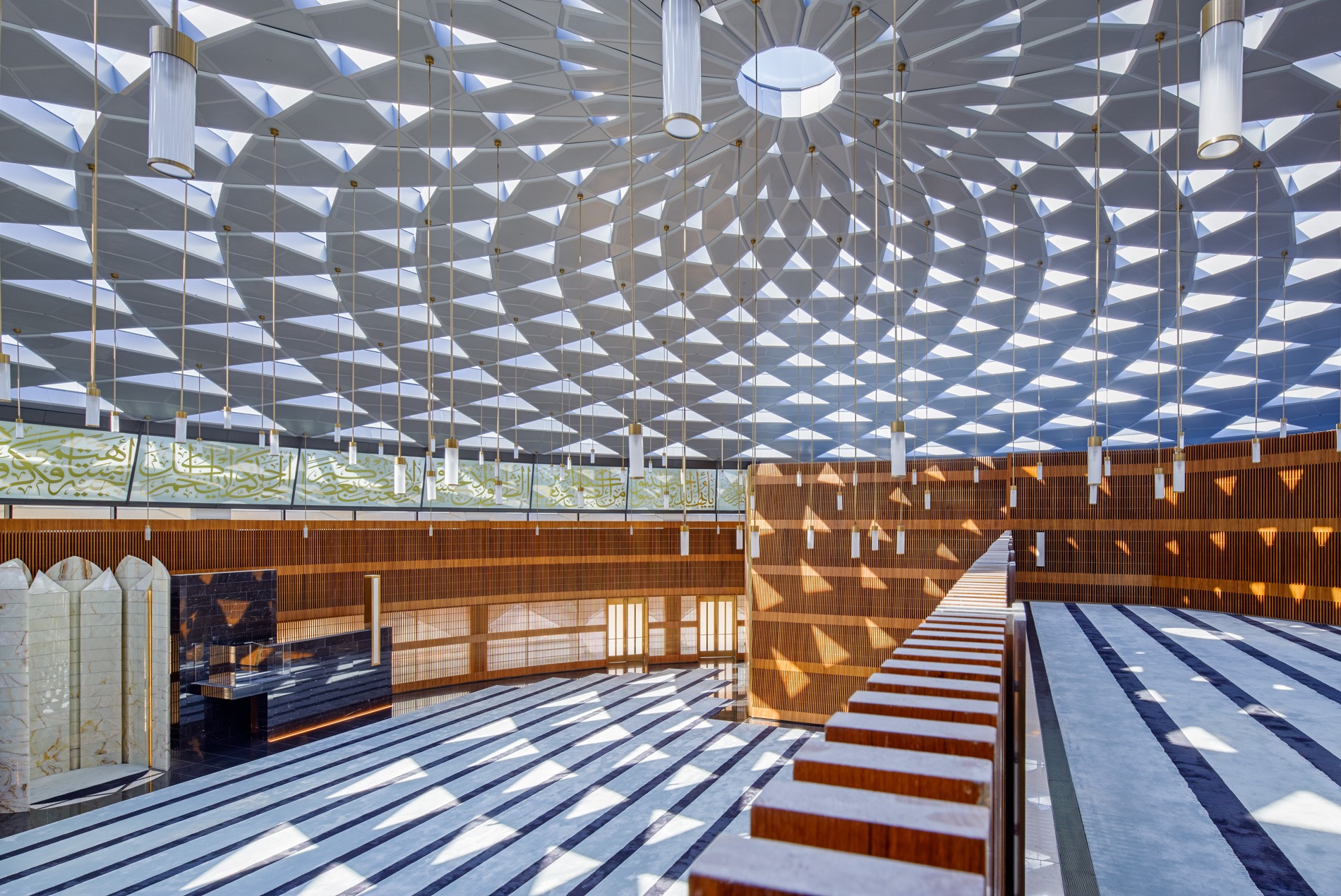 Public mosque interior with skylights, natural light and warm woods at HOK-designed Hamad International Airport in Qatar