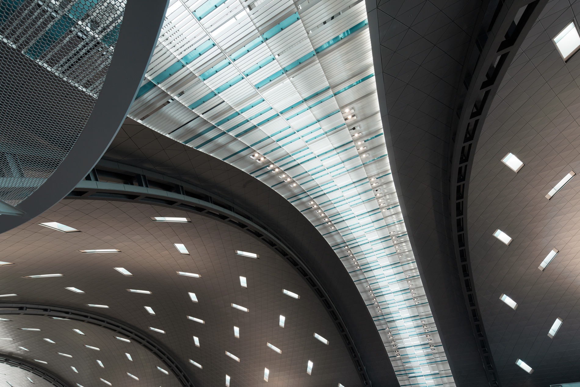 Interior photo of the departures hall and curved metal ceiling inside HOK-designed Hamad International Airport.