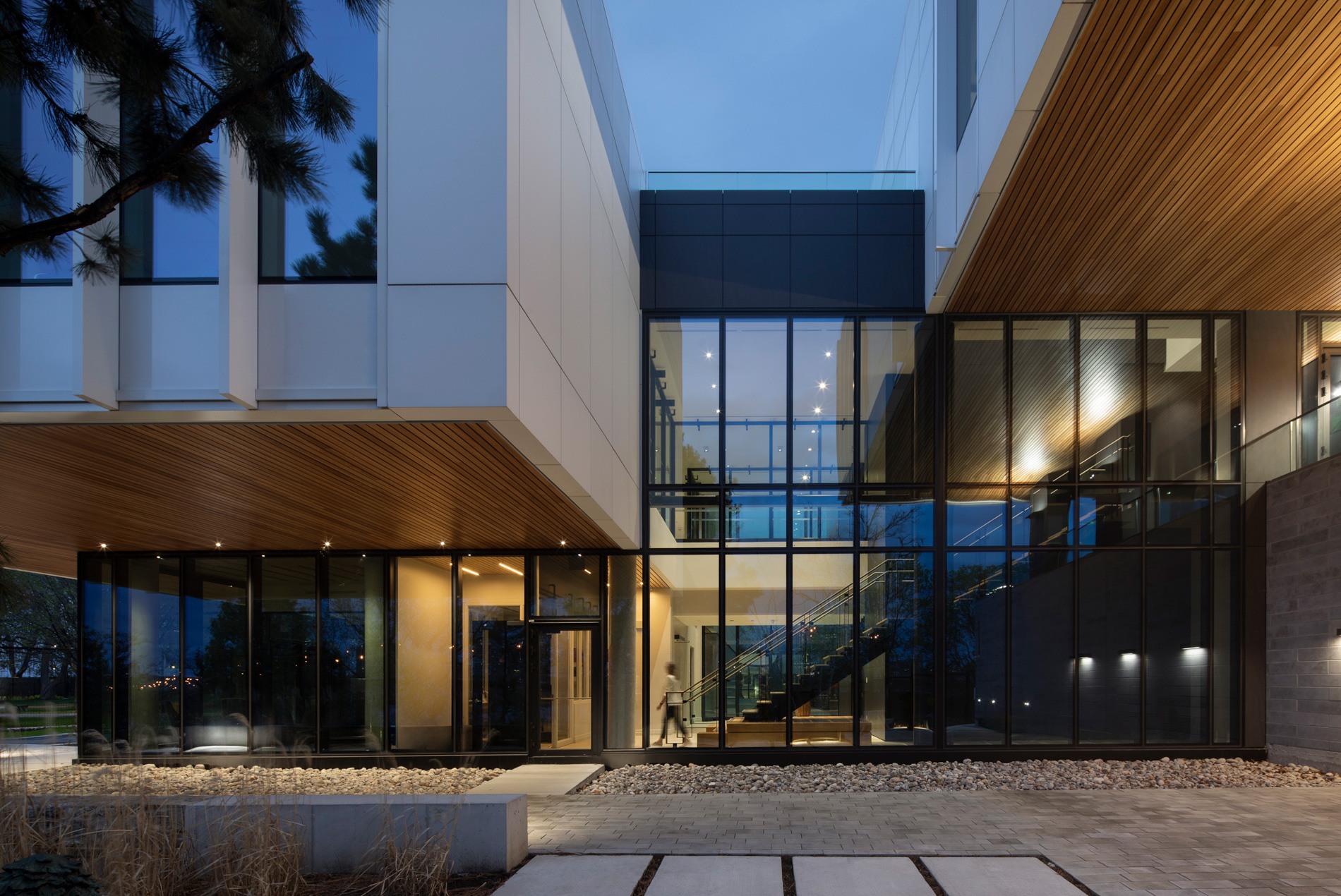 HOK-designed British High Commission exterior showing the building entryway at dusk with full length windows into the building.