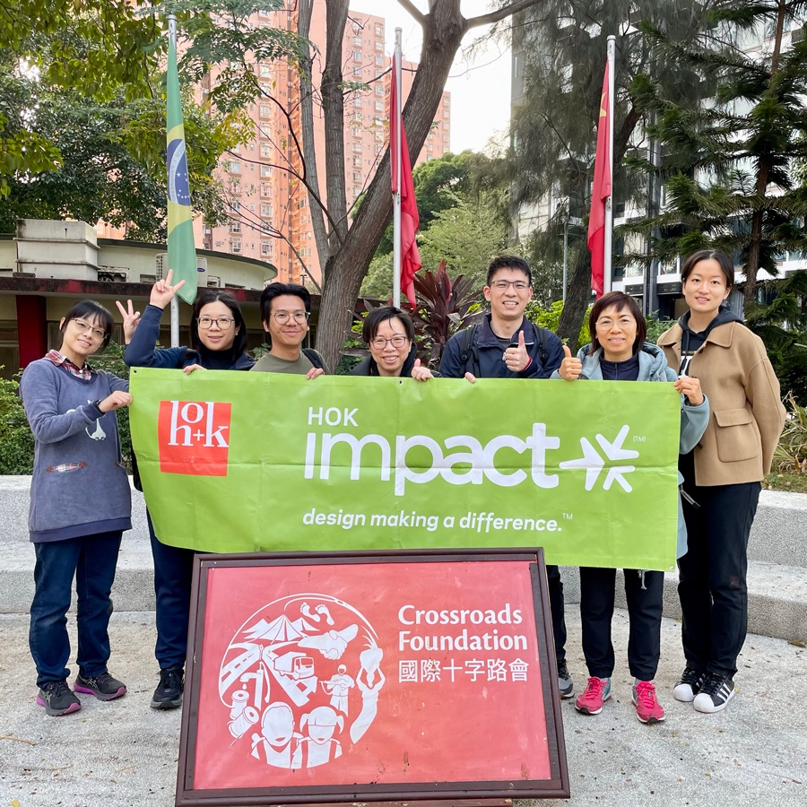 A group of HOK Hong Kong employees posing with an HOK Impact volunteer group banner for the Crossroads Foundation in Hong Kong.