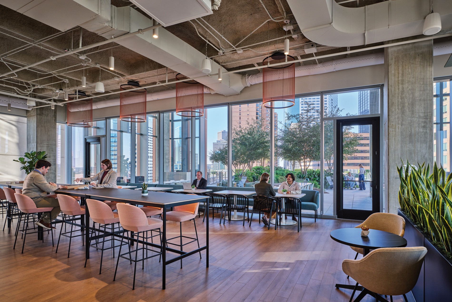 Lounge space with plantings and views to an outdoor terrace at a confidential Houston office designed by HOK