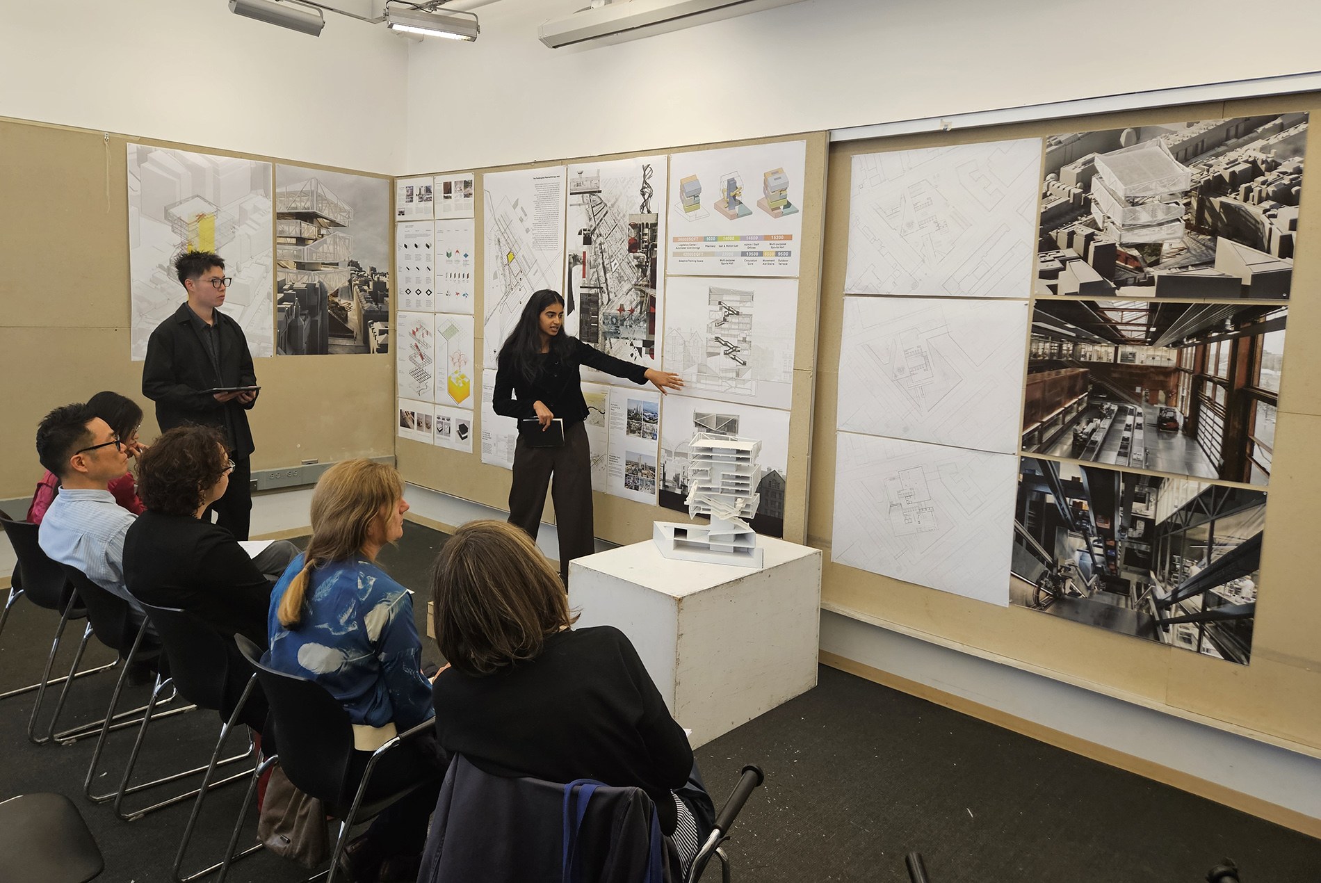 Syracuse University architectural student presenting final review to HOK's Francesca Oliveira and Kathrin Brunner.