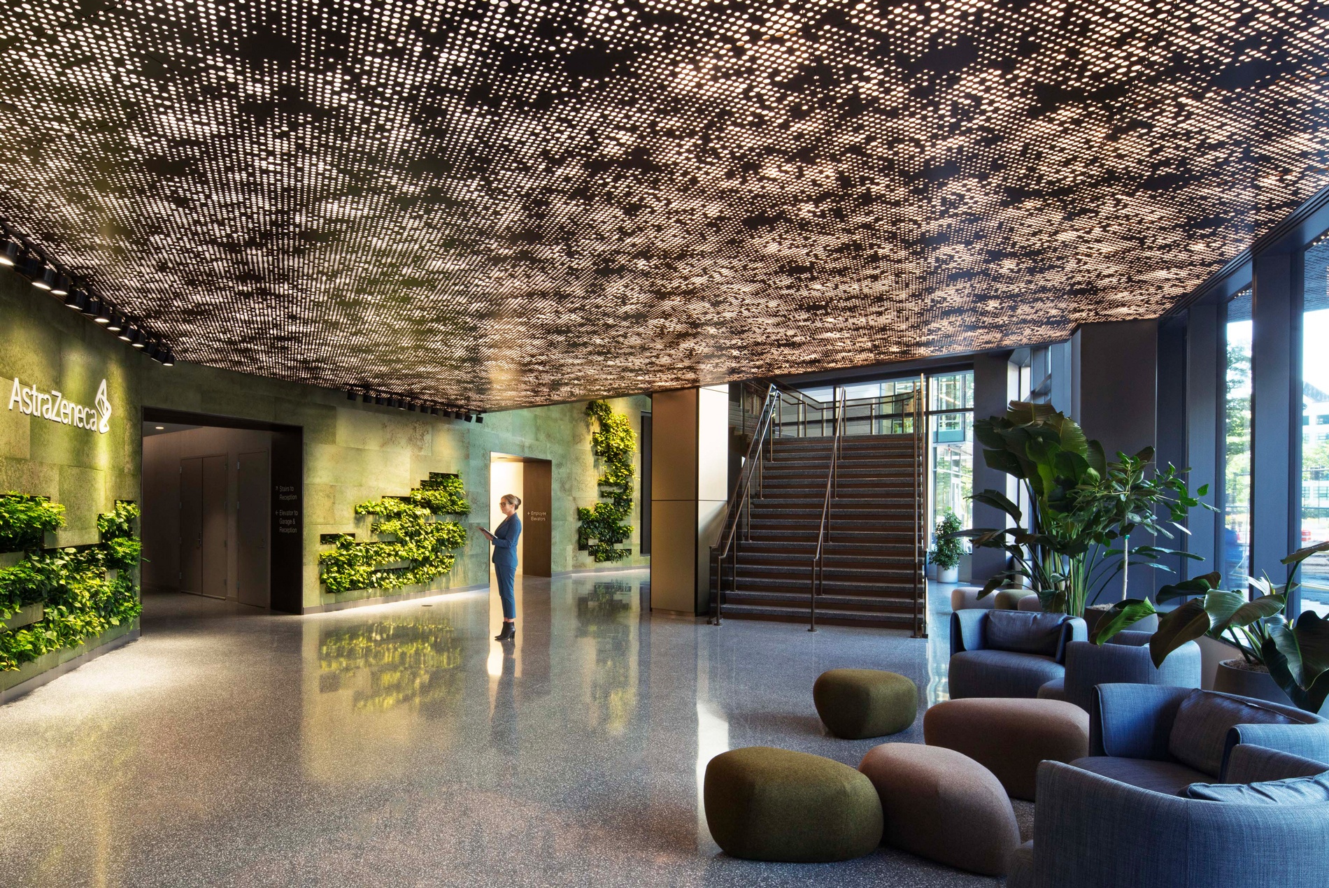 lobby of astrazeneca r&d hub with custom ceiling green walls and signage